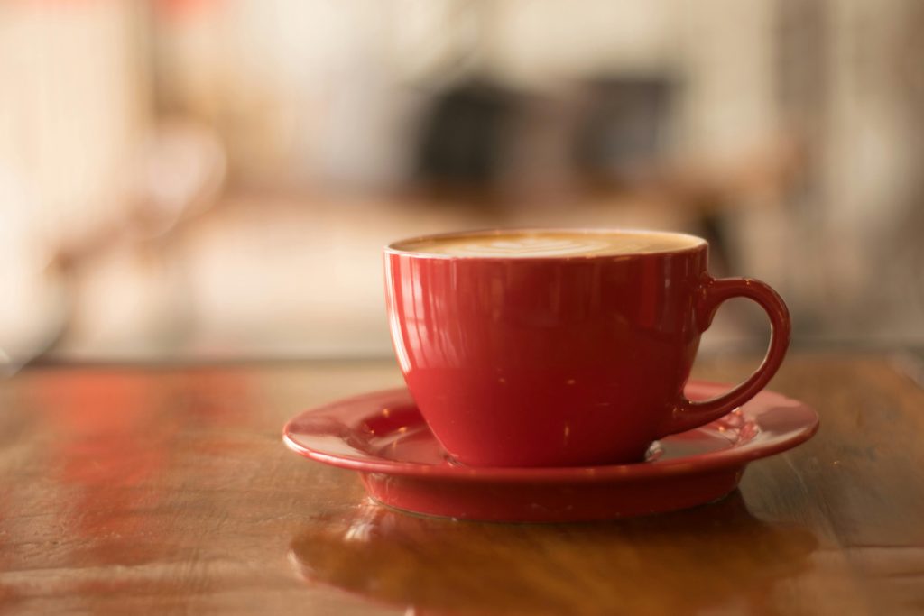 pexels-photo-1187317-1187317 Cozy atmosphere with a cappuccino in a red cup on a wooden table, perfect for coffee lovers.